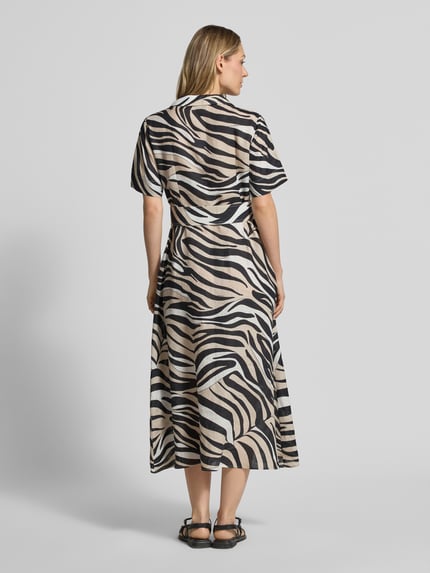 Vrouwenmodel draagt dames jurk uit zuiver linnen met reverskraag model 'SPACCHE' van Marella, getailleerde pasvorm, 1/2-mouwen, maxilengte, riem, zebra print, ruglengte bij maat 36: 126 cm, borstwijdte: 47 cm, mouwlengte: 24 cm, geheel van achteren bekeken.