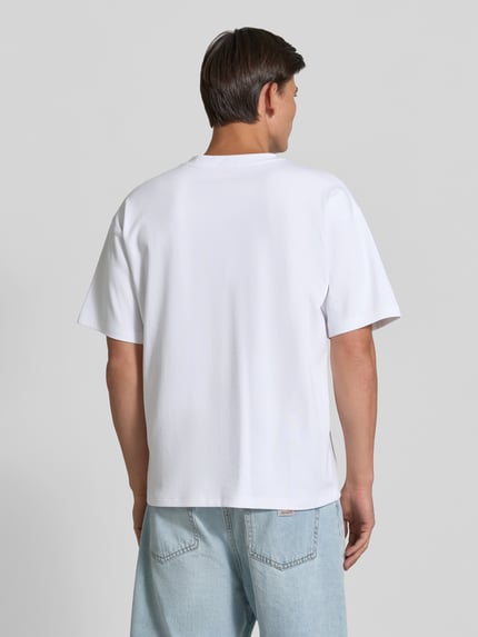 Männermodel trägt weißes T-Shirt mit überschnittenen Schultern von Diesel, lockere Passform, Baumwoll-Elasthan-Mix, Rückenansicht.
