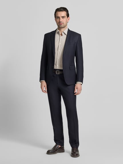 Männermodel trägt Regular Fit Businesshemd mit Kombimanschette Modell 'P-JOE-K' von BOSS in Unifarbe und Gitterkaro, Ganzkörperansicht von vorne.