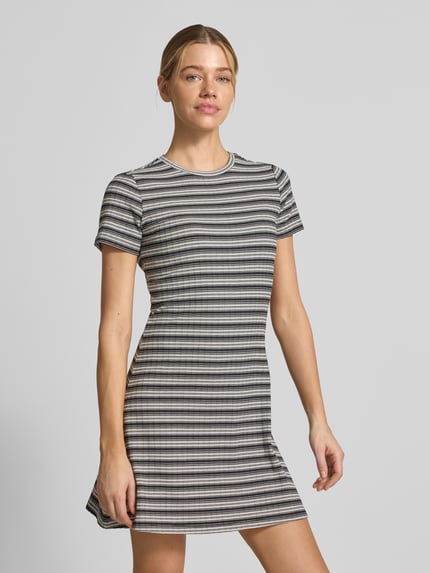 Frauenmodel trägt Körpernahes Freizeitkleid mit Allover-Muster von Tom Tailor Denim, Optik:Allover-Muster, Passform:Körpernah, Länge:Knielang, Ausschnitt:Rundhals, Ärmelform:Kurzarm, Saum:Gerade, Materialverarbeitung:Ripp, gestreiftes Design in Grau- und Schwarztönen, gerippte Textur, Ganzkörperansicht von vorne.