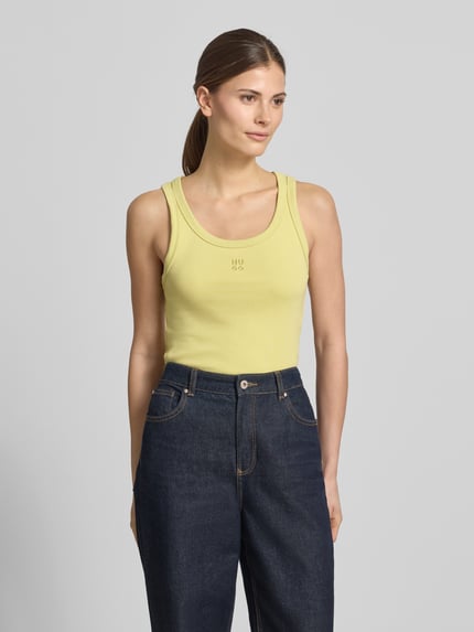 Frauenmodel trägt Slim Fit Tank Top aus Baumwoll-Mix Modell 'DATAMIA' von HUGO in Uni-Optik mit Label Stitching, U-Ausschnitt, breite Träger, Feinrippstruktur, Ganzkörperansicht von vorne.