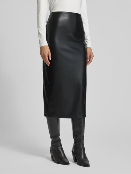 Frauenmodel trägt Midirock in Leder-Optik von ZABAIONE, körpernahe Passform in Schwarz, glatte Textur, Ganzkörperansicht von vorne.