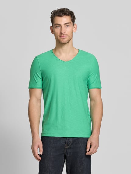 Męski model nosi Regular Fit T-Shirt mit V-Ausschnitt von MCNEAL, bawełna, krój regular fit, zrolowany brzeg, długość tyłu 70 cm, Ganzkörperansicht von vorne.