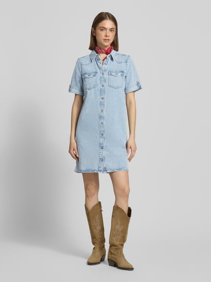 Frauenmodel trägt körpernahes, kurzes Jeanskleid aus Baumwoll-Viskose-Mix Modell 'LISA' von Only in Hellblau mit kurzem Arm, unifarbenem Denim und Brusttaschen, Ganzkörperansicht von vorne.