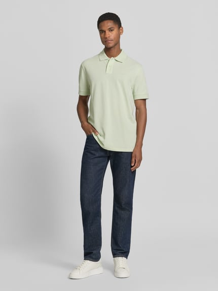 Mannelijk model draagt Regular Fit Poloshirt uit puur katoen model 'PRIME' van BOSS Orange, look: effen, piqué, labelpatch, polokraag, V-hals, korte knoopsluiting, korte mouw met geribd, materiaalverwerking: puur katoen, Ganzkörperansicht van voren.