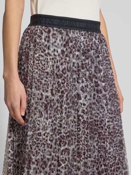 Vrouwenmodel draagt Midirok in plooienlook met all-over dierenprint van Marc Cain, licht a-lijn, elastische band, logostitching, detailopname taille