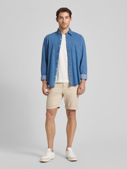 Männermodel trägt Slim Fit Chinoshorts aus Baumwoll-Mix Modell 'SLIM-LUTON' von SELECTED HOMME, Optik: Unifarben, feine Webstruktur, Ganzkörperansicht von vorne.