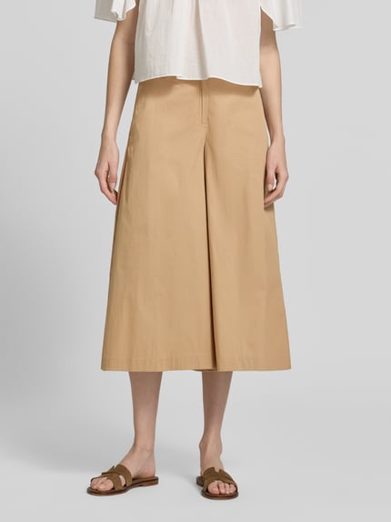 Kobiecy model nosi Regular Fit Culotte aus Baumwoll-Mix Modell 'MELLI' von Brax, efekt: jednolity kolor, krój regular fit, zapięcie na guzik i ukryty zamek błyskawiczny, elastyczny pas z tunelem, wpuszczane kieszenie boczne, kieszenie z tyłu, wykończenie materiału: popelina, mieszanka bawełny, jasnobeżowy odcień, gładka tekstura, szerokie nogawki, Ganzkörperansicht von vorne.