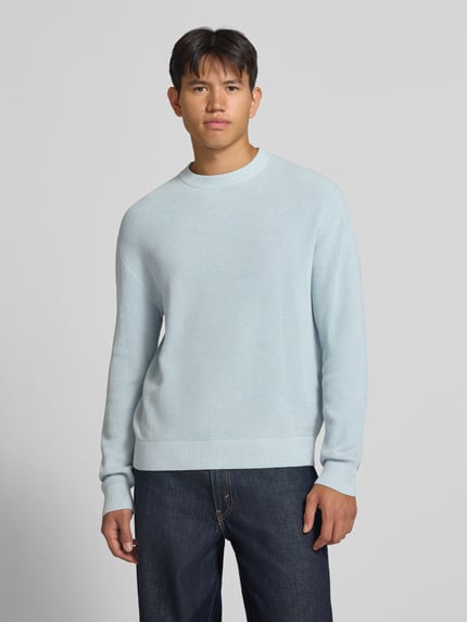 Männermodel trägt Regular Fit Strickpullover aus reiner Baumwolle von REVIEW in Hellblau, feine Struktur, Rundhalsausschnitt, Ganzkörperansicht von vorne.