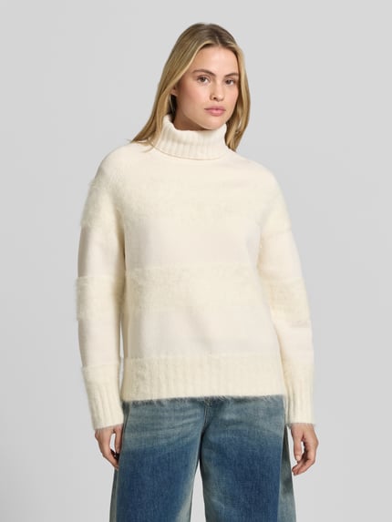 Frauenmodel trägt Pullover aus Alpaka mit Rollkragen Modell 'Mila' von Joseph, cremefarben, Struktur-Strick, lange Raglanärmel, Nahaufnahme Oberkörper.