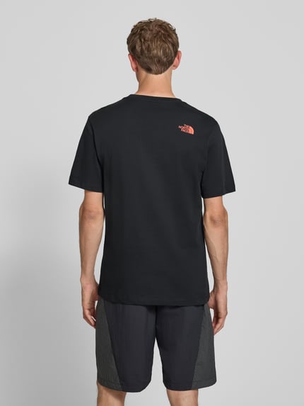 Männermodel trägt T-Shirt mit Label-Print und Rundhalsausschnitt von The North Face aus Reine Baumwolle im Regular-Fit, Rückenlänge 74 cm, Ganzkörperansicht Rückansicht.