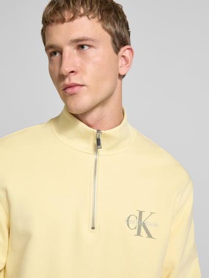 Männermodel trägt Sweatshirt mit Stehkragen und Reißverschluss von Calvin Klein Jeans, Regular-Fit, reine Baumwolle, Logo, Nahaufnahme Oberkörper.