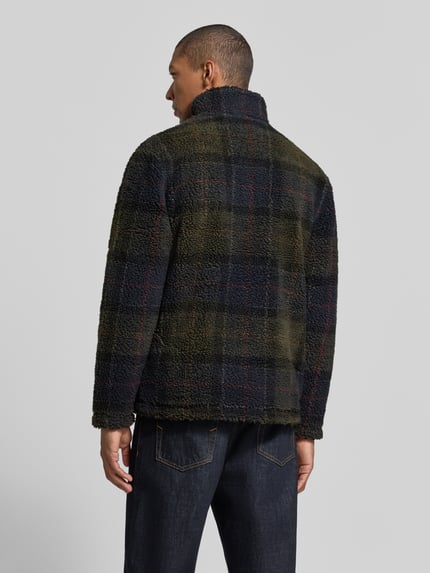 Männermodel trägt kurtka z polaru mit stójka von Barbour, wielokolorowy wzór w kratkę, długi rękaw, zamek błyskawiczny, wpuszczane kieszenie, wyhaftowane logo, faktura miękkiego polaru, Ganzkörperansicht Rückansicht.