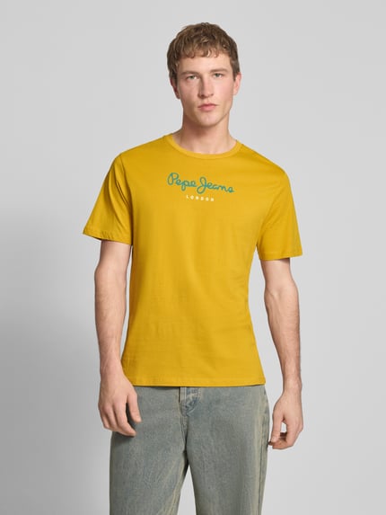 Männermodel trägt Regular Fit T-Shirt aus reiner Baumwolle Modell 'EGGO' von Pepe Jeans in Gelb, Optik: Unifarben, Ganzkörperansicht von vorne.