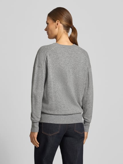 Frauenmodel trägt Pullover aus Wolle mit V-Ausschnitt von JAKE*S WOMAN CASUAL in grauer Melange, Feinstrick, gerippte Abschlüsse, Ganzkörperansicht Rückansicht.