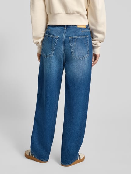 Vrouwenmodel draagt Barrel Fit Jeans uit pure katoen model 'HAAYI' van Armedangels in blauwe melange, losse pasvorm, lage taille, 5-pocket design, detox denim. Volledige lichaamsopname achteraanzicht.