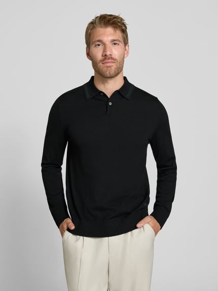 Männermodel trägt Regular Fit Poloshirt in Strick-Optik von Paul Smith aus reiner Wolle, schwarz, gerippte Abschlüsse, Nahaufnahme Oberkörper.