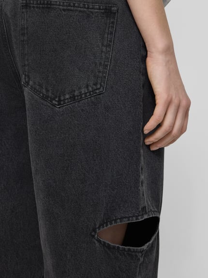Frauenmodel trägt Wide Leg Jeans mit Cut Out von Karo Kauer, Reine Baumwolle, 5-Pocket-Design, schwarze Denim-Optik, Detailaufnahme Oberschenkel.
