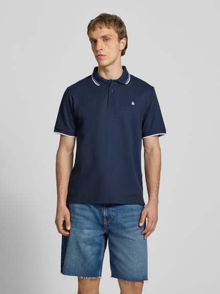 Männermodel trägt Regular Fit Poloshirt mit Strukturmuster Modell 'AUSTIN' von Jack & Jones, Dunkelblau, Baumwoll-Mix, Knopfleiste, Stitching, Ganzkörperansicht von vorne.