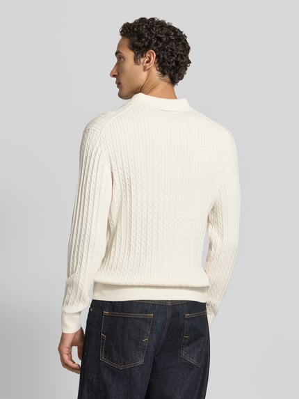 Männermodel trägt Strickpullover mit Polokragen und kurzer Knopfleiste von MCNEAL, krój regular fit, czysty bawełna, wzór warkoczowy, żebrowane wykończenia, długość tyłu w rozmiarze M: 71 cm, długość rękawa w rozmiarze M: 78 cm, widok całej sylwetki z tyłu