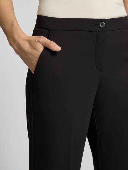 Männermodel trägt czarne spodnie z szerokimi nogawkami z wpuszczanymi kieszeniami Wide Leg Hose mit Eingrifftaschen Modell 'Hillda' von Stehmann, zbliżenie na górną część spodni