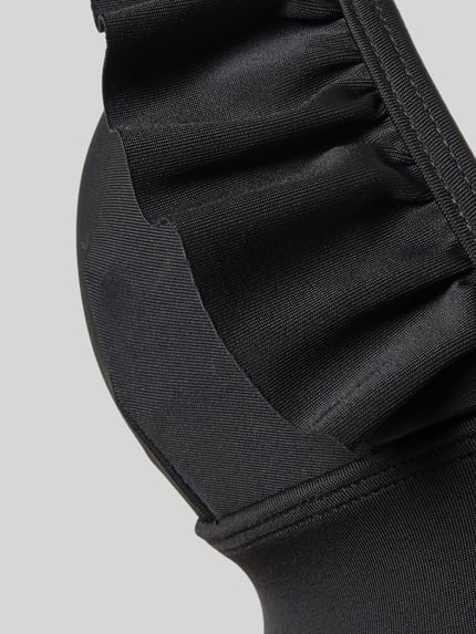 Vrouwenmodel draagt bikini-set met ruches model 'BOBBY' van Shiwi, materiaalmix met stretch, nauwsluitende pasvorm, detailopname.