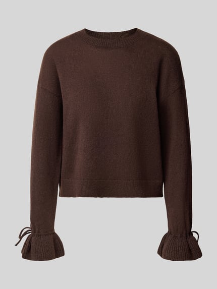 Produktfoto, Pullover mit Rüschenärmeln von PIECES, jednolity brązowy kolor, dzianinowa struktura, okrągły dekolt, długie rękawy z falbanami i wiązaniem, dół żebrowany, aplikacje w postaci falban oraz kokardki