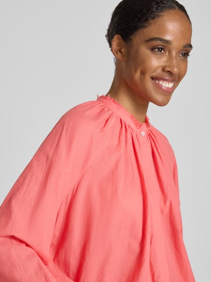 Frauenmodel trägt Relaxed Fit Bluse mit Stehkragen von More & More in leuchtendem Pink aus Reine Baumwolle, Raffung, Langärmelig, Nahaufnahme Oberkörper.
