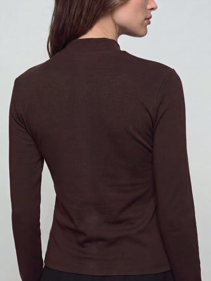 Frauenmodel trägt Slim Fit Langarmshirt aus reiner Baumwolle von Tommy Hilfiger in Dunkelbraun, glatte Textur, Ganzkörperansicht Rückansicht. Damen Langarmshirt von Tommy Hilfiger