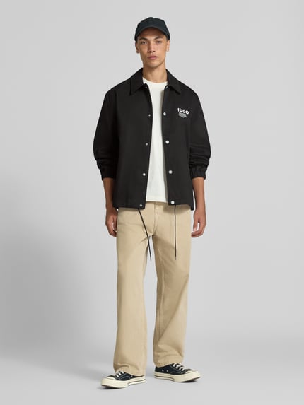 Männermodel trägt Regular Fit Bomberjacke / Blouson aus reiner Baumwolle Modell 'Biyo2631' von HUGO, Herren Bomberjacke / Blouson, Ganzkörperansicht von vorne.