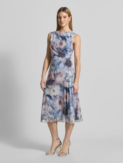 Frauenmodel trägt Regular Fit Midikleid mit Raffungen von Swing aus Elastischer-Material-Mix mit Mesh, floraler-Allover-Print, ärmelloses-Design, Rundhalsausschnitt, taillierte-Passform, blickdichter-Unterrock, ganzkörperansicht-von-vorne.