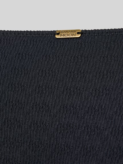 Produktfoto, Bikini-Slip mit Label-Detail Modell 'MASSA' von Banana Moon im schwarzen Material-Mix mit Stretch-Anteil und feiner Struktur.