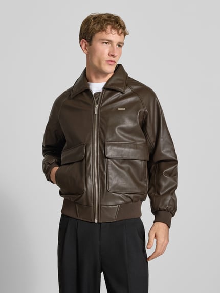 Männermodel trägt Regular Fit Jacke in Leder-Optik Modell 'MORANO' von PEGADOR, braun, Umlegekragen, Reißverschluss, Ganzkörperansicht von vorne.