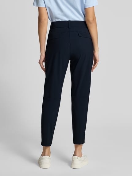 Frauenmodel trägt Stoffhose in 7/8-Länge mit Stretch-Anteil Modell 'NATINA' von Raffaello Rossi aus Elastischer-Material-Mix, Farbe Dunkelblau, körpernahe Passform, Elastikbund mit Gürtelschlaufen, Reißverschlusstaschen, Bundweite bei Größe 36: 40 cm, Innenbeinlänge 69 cm, Ganzkörperansicht Rückansicht.