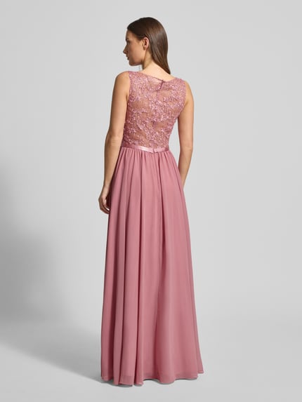 Frauenmodel trägt Abendkleid mit Paillettenbesatz von LUXUAR FASHION in Rosa mit transparentem Rücken und Zier-Stitchings, Ganzkörperansicht Rückansicht.