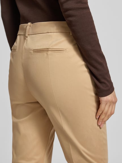 Vrouwenmodel draagt beige Stoffhose met französischen Eingrifftaschen Modell 'DAYS' van B.Young, katoen-elastaan mix, rechte snit, achterzakken, knoop- en ritssluiting, stoffen ceintuur, detailopname heupen.