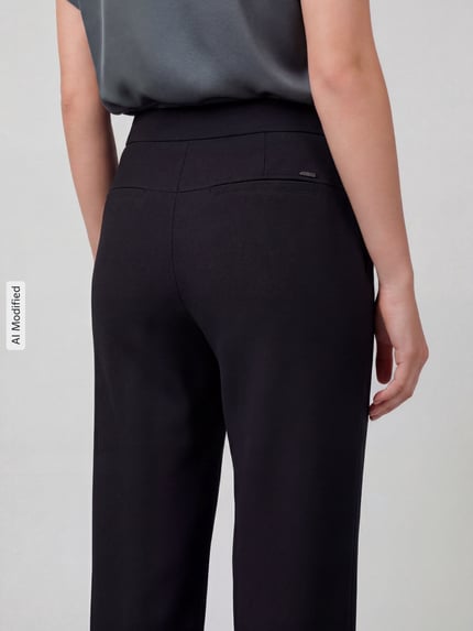 Kobieta prezentuje spodnie Regular Fit Barrel Leg Hose mit Label-Detail Model 'PHIBI' od Raffaello Rossi, efekt: jednolity kolor, krój regular fit, wysoki stan, detal z logo, elastyczny ściągacz, wpuszczane kieszenie boczne i kieszeń z tyłu, wykończenie materiału: dzianina dresowa, jednokolorowe, zdjęcie: widok całej sylwetki z tyłu.