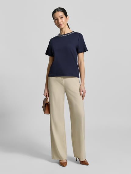 Vrouwenmodel draagt T-shirt met Perlen und Ziersteinbesatz van Christian Berg Woman van puur katoen, regular fit, ronde hals, donkerblauw, ruglengte bij maat S 53 cm, Ganzkörperansicht von vorne.