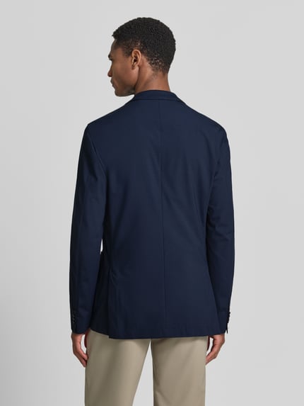 Męski model nosi Slim Fit Anzugsakko mit Reverskragen Modell 'P-HANRY-J-WG-233' von BOSS, efekt: jednolity kolor, zaszewki, kołnierz z połami, listwa z 2 guzikami, długi rękaw, nachodzące na siebie guziki, brustasza, nakładane kieszenie boczne, wykończenie materiału: four-way-stretch, Ganzkörperansicht Rückansicht.