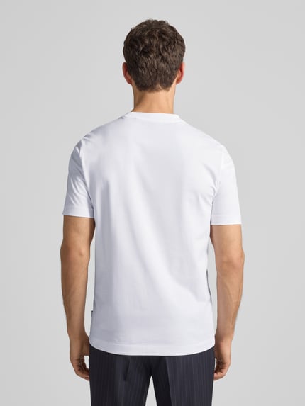 Männermodel trägt weißes T-Shirt aus Baumwolle Modell 'Thompson' von BOSS, gerade Passform, Rückenlänge 71 cm, Ganzkörperansicht Rückansicht.