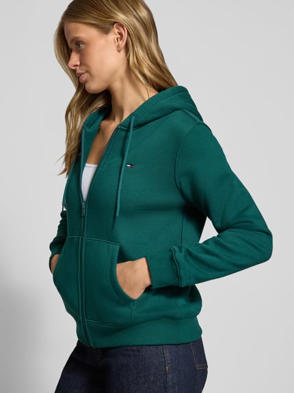 Vrouwenmodel draagt groene regular fit sweatjack van katoenmix Regular Fit Sweatjacke aus Baumwoll-Mix van Tommy Jeans, zijaanzicht bovenlichaam, Dames Sweatjacke van Tommy Jeans