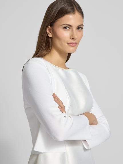 Frauenmodel trägt Regular Fit Bolero aus Viskose-Mix in Strick-Optik von Jake*s Cocktail in Weiß, leicht glänzende Textur, Nahaufnahme Oberkörper.