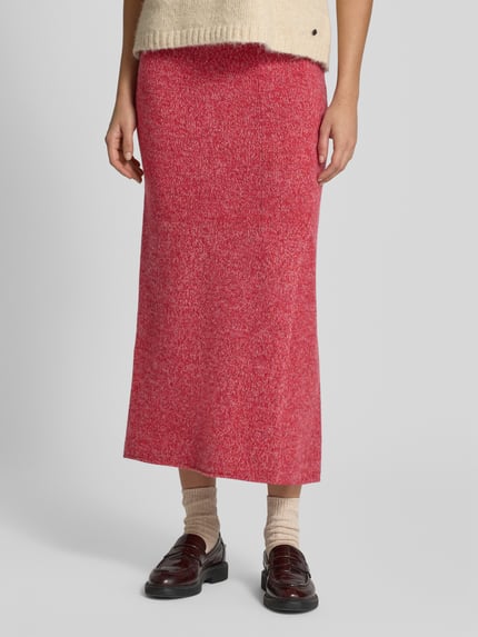 Frauenmodel trägt Strickrock aus Wolle in Two-Tone-Machart von Christian Berg Woman, Rotton, gerader Schnitt, elastischer Bund, Nahaufnahme Unterkörper.