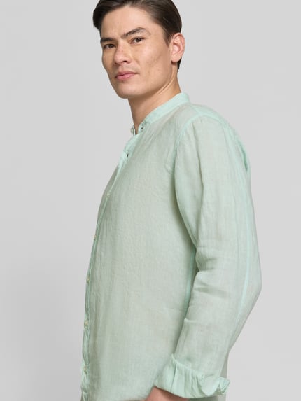 Männermodel trägt Regular Fit Freizeithemd aus reinem Leinen Modell 'RACE_1_M' von BOSS Orange in Hellgrün, Mao-Kragen, Langarm, unifarben, Nahaufnahme Oberkörper.