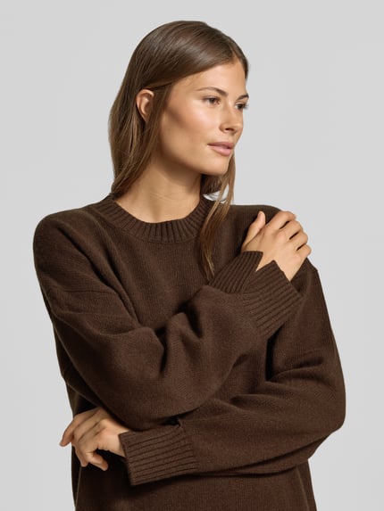 Vrouwenmodel draagt Regular Fit Pullover aus Woll-Mix mit Kaschmir-Anteil van MYON, bruine Tricotlook, ronde hals, ruglengte maat 36 63 cm, mouwlengte maat 36 64 cm, Nahaufnahme bovenlichaam.