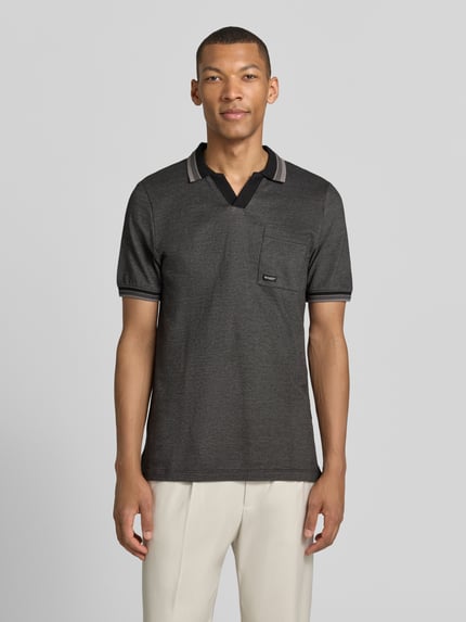 Männermodel trägt Regular Fit Poloshirt aus reiner Baumwolle Modell 'OPEN COLLAR POLO' von s.Oliver RED LABEL in Melange-Optik, Piqué-Textur, kurzarm, mit Brusttasche, Ganzkörperansicht von vorne.