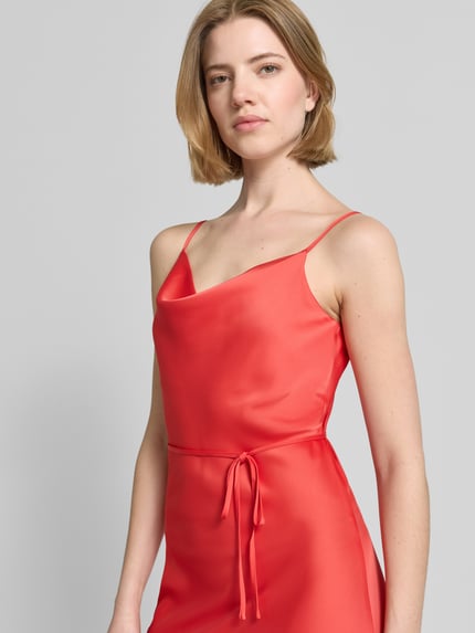 Frauenmodel trägt Cocktailkleid mit Spaghettiträgern Modell 'THEA' von YAS in Rot, Satin, gerader Schnitt, Nahaufnahme Oberkörper.