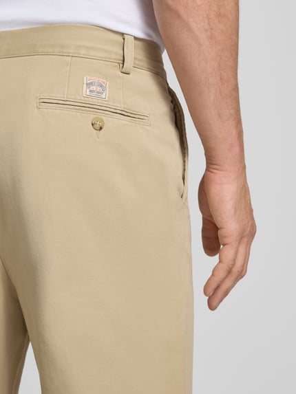 Männermodel trägt Chino mit gelegten Falten und Gesäßtaschen von Polo Ralph Lauren in Beige, reine Baumwolle, Nahaufnahme Rückansicht