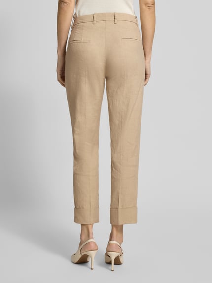 Vrouwenmodel draagt Leinenhose mit Baumwoll-Anteil van Cambio in beige, straight fit, verkorte pasvorm, met riemlussen, detailopname rugaanzicht.