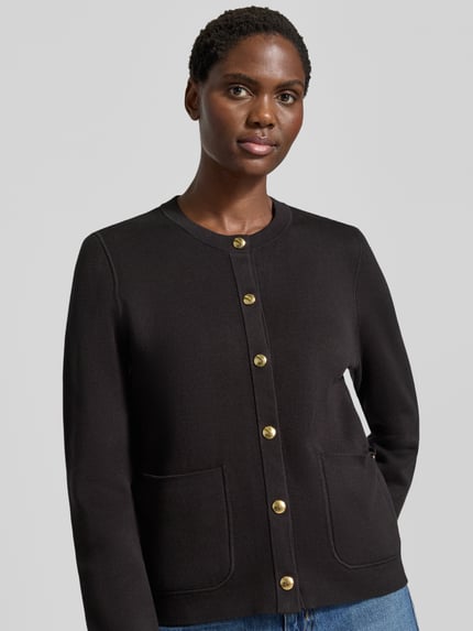 Frauenmodel trägt Regular Fit Strickjacke aus Baumwoll-Mix von Tommy Hilfiger in Schwarz mit goldenen Knöpfen, Nahaufnahme Oberkörper, Damen Strickjacke.